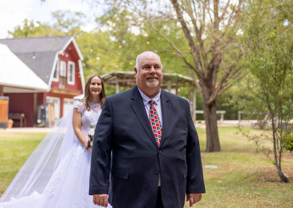 A bride and her dad having a first look at a rustic outdoor wedding venue in Austin