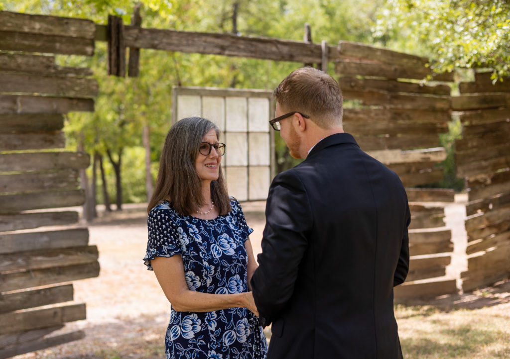 A groom and his mom have their first look at an outdoor wedding venue in Austin