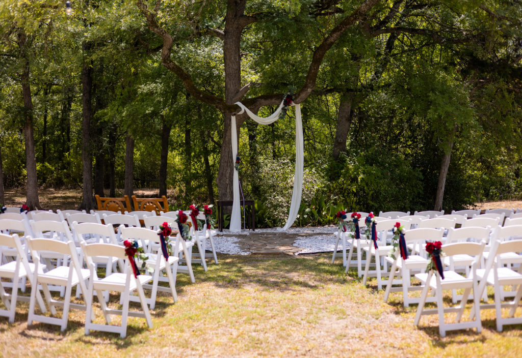 An outdoor wedding venue ceremony set up underneath trees