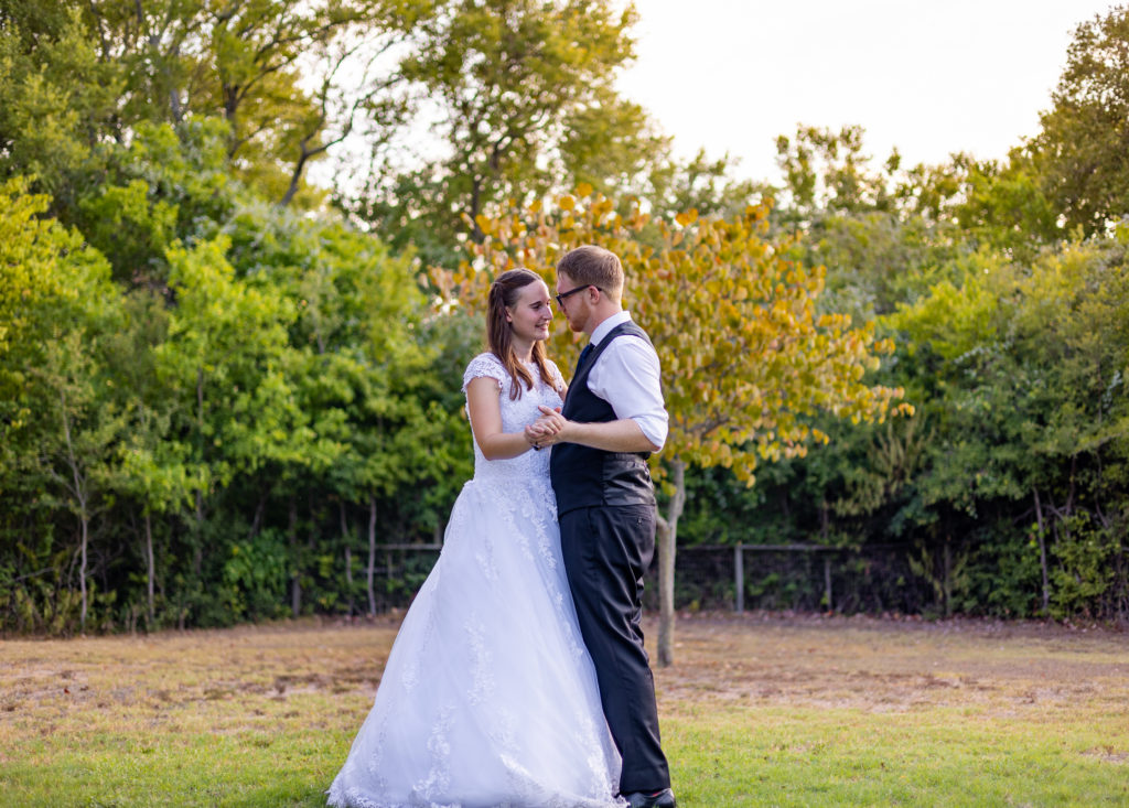 A bride and groom dance in an open field on wedding day in Austin